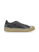 Sneaker de estilo urbano confeccionado en cueros mixtos con acabado de glitter negro en los laterales, puntera metalizada y suela de goma en tono miel. Presenta cordones con hilo de lurex.