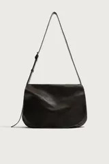 Bolso bandolera de piel color marrón oscuro, con diseño flexible y solapa frontal. Cuenta con asa larga ajustable y compartimento principal con bolsillo interior con cierre.