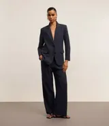 Pantalón de vestir azul marino, de corte wide leg, con cintura alta, pliegues frontales, bolsillos laterales y aplicación de strass.