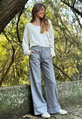 Pantalón gris de corte palazzo con cintura alta y detalle de costuras verticales en el frente.