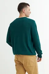 Sweater verde oscuro de tejido de punto, con escote en V y mangas largas.