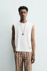 Musculosa de corte relajado con cuello redondo y sisas amplias. Presenta un pequeño bordado de plátanos en la parte inferior frontal.