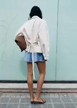Short celeste con sutiles rayas verticales blancas, de tiro regular y silueta relajada, con cintura elástica.