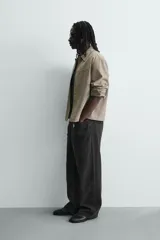 Sobrecamisa boxy fit de hombre confeccionada en tejido efecto ante color beige, con cuello solapa, manga larga con puño abotonado, bolsillo de parche en el pecho y cierre frontal con botones a presión ocultos.