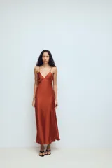 Vestido midi de tejido satinado color terracota, con escote en pico, tirantes finos ajustables y espalda con tiras cruzadas.