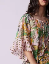Blusa de gasa estampada con cuello a la base y lazo. Tiene plisado en la delantera, detalles de brillo en lurex, abertura central con botones y mangas 3/4 fluidas.