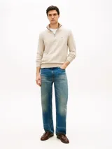 Sweater de punto color beige con cuello perkins, cierre frontal con cremallera corta y manga larga. Presenta detalles de rib en cuello, puños y dobladillo, además del logo bordado en el pecho de Tommy Hilfiger.