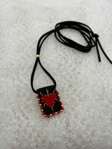 Collar con dije rectangular bordado con un corazón rojo y detalles de mostacillas de colores.