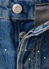 Jeans de denim azul de corte wide leg, con aplicación de pequeños tachas o strass plateados en toda la prenda.