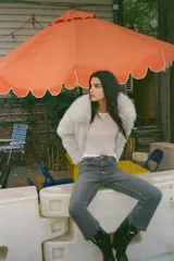 Jeans de tiro alto color marrón oscuro con acabado lavado, corte recto/flare y bajo cropped sin costuras. Presenta cinco bolsillos y cierre frontal con cremallera y botón metálico.