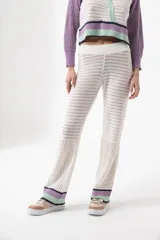 Pantalón de tejido de punto calado color crudo, de corte recto y cintura alta.