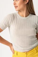 Remera color beige de tejido de punto con textura acanalada vertical.