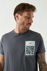 Remera gris de algodón con bolsillo en el pecho con estampado de hojas.