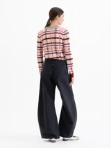 Jeans de corte wide leg y estilo balloon, color negro lavado. Presenta pinzas y recortes estratégicos en las piernas que aportan volumen y movimiento. De tiro medio, confeccionado en tejido de algodón liviano.