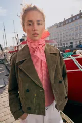 Trench corto de Zara confeccionado en piel de ante, con cuello de solapa, cierre frontal cruzado con botones, mangas largas con trabillas y bolsillos delanteros de vivo.