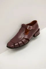 Sandalias Mary Jane de cuero color bordeaux, con diseño de tiras cruzadas, puntera cuadrada y taco bajo.