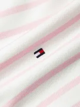 Chomba de piqué de algodón elástico a rayas horizontales blancas y rosas, con cuello polo rosa con ribete rojo, cartera con botones, corte regular, manga corta y logo de Tommy Hilfiger bordado en el pecho.