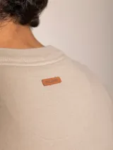 Sweater azul marino de algodón con cuello en V y logo bordado en el pecho.