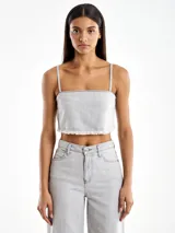 Top gris de denim con tirantes finos y ruedo desflecado.