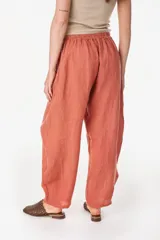 Pantalón de lino italiano color terracota, de corte relajado y fluido con cintura elástica fruncida.