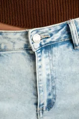 Jean de corte wide leg con tiro medio, confeccionado en denim de algodón con un lavado claro desgastado. Presenta diseño de cinco bolsillos y cierre frontal con botón y cremallera.