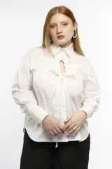 Camisa oversize de manga larga en color blanco, confeccionada en algodón. Presenta cuello clásico, puños abotonados y una abertura central ovalada con jaretas ajustables que permiten fruncir la prenda.