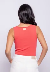 Top negro de tejido de punto ajustado al cuerpo con abertura circular en el pecho y cuello redondo.