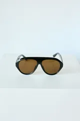 Lentes de sol con armazón de policarbonato negro y diseño estilo aviador con puente superior recto. Cuentan con protección UV400 e incluyen estuche.