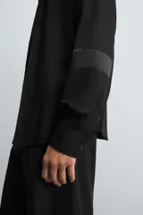 Camisa blanca de manga larga con cuello italiano y cierre frontal de botonadura. Corte regular fit.