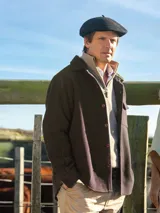 Camisa leñadora de paño color marrón oscuro, confeccionada en lana, de manga larga con bolsillos en el pecho y cierre frontal con botones.