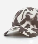 Gorra de sarga con estampado animal print de vaca, modelo dad hat con visera curva y ajuste trasero. Confeccionada en algodón sostenible.