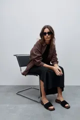Vestido midi negro de algodón con calce relajado, silueta recta, cuello redondo, mangas cortas amplias y tajos laterales.