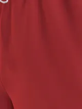 Short de baño rojo de poliéster reciclado con cintura elástica ajustable con cordón blanco, logo de Tommy Jeans estampado verticalmente en el lateral y ribete blanco en el ruedo.