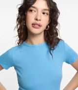 Blusa básica de manga corta, cuello redondo y textura sutil, confeccionada en viscosa con elastano. El bajo de la prenda es ondulado.