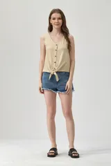 Musculosa color beige con escote en V, sin mangas, con botones y nudo en la parte inferior.