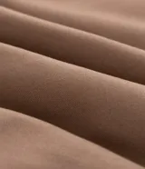 Campera bomber de sarga color tostado con cuello desmontable de pelo sintético oscuro. Presenta cierre frontal de cremallera, puños y cintura acanalados, y bolsillos laterales.