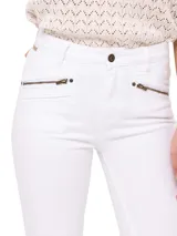 Jeans skinny de tiro medio color blanco, con cierre frontal, bolsillos delanteros con cierre y ruedo desflecado.