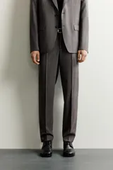 Pantalón de vestir regular fit color gris con sutil patrón a cuadros, confeccionado con mezcla de lana. Cuenta con bolsillos frontales, bolsillos traseros de doble vivo con botón, trabillas para cinturón y raya marcada en las piernas.