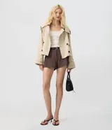 Short de sastrería color marrón, con diseño estructurado, pinzas delanteras, largo mini y presillas para cinturón. Incluye un cinturón delgado.