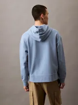 Buzo con capucha celeste de algodón con logo Calvin Klein estampado en el pecho. Tiene bolsillo tipo canguro, puños y dobladillo acanalados, y corte relaxed.