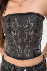 Top strapless de denim negro con efecto acid wash y diseño de stencils de pedrería brillante en el frente.
