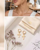 Caravanas tipo argolla doradas de acero, con engaste de circonias brillantes y dije colgante en forma de cruz.