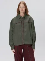 Camisa western de algodón grueso color verde militar, con corte holgado y aplicaciones de hilo en contraste en el pecho, la cartera de botones y los puños.