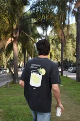 Remera de algodón 100% peinado color negro con efecto gastado, de corte recto y manga corta. Presenta un estampado gráfico en la espalda con diseño pixelado de un vaso con limonada, rodajas de limón, hojas de menta y la inscripción "summer flavor".