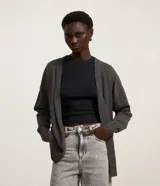 Cardigan de punto en color gris oscuro, con diseño abierto sin botones, mangas largas y corte largo.