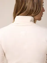 Remera de manga larga con cuello tortuga, confeccionada en tejido de algodón con elastano, de corte ajustado al cuerpo y diseño liso.