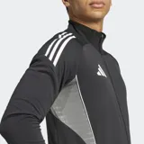 Campera deportiva Adidas negra con cierre frontal completo y cuello alto. Presenta tres franjas blancas en los hombros y paneles laterales de malla en gris claro. Incluye bolsillos delanteros con cierre.