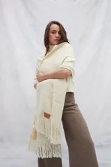 Chal de lana sin teñir, color crema, con flecos en los extremos.
