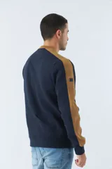 Buzo color bordó con cuello redondo y mangas largas con detalle de franja negra en los hombros. Tiene puños y logo "Mistral" estampado en relieve en el pecho.