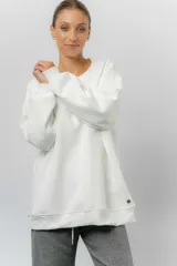 Buzo oversize de cuello redondo, confeccionado en algodón suave con interior frizado. Presenta un diseño de líneas simples, corte relajado y mangas largas con puños ajustados.